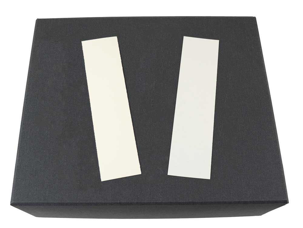 Two bookmarks made from archival, acid-free paper on top of a rare book box.
